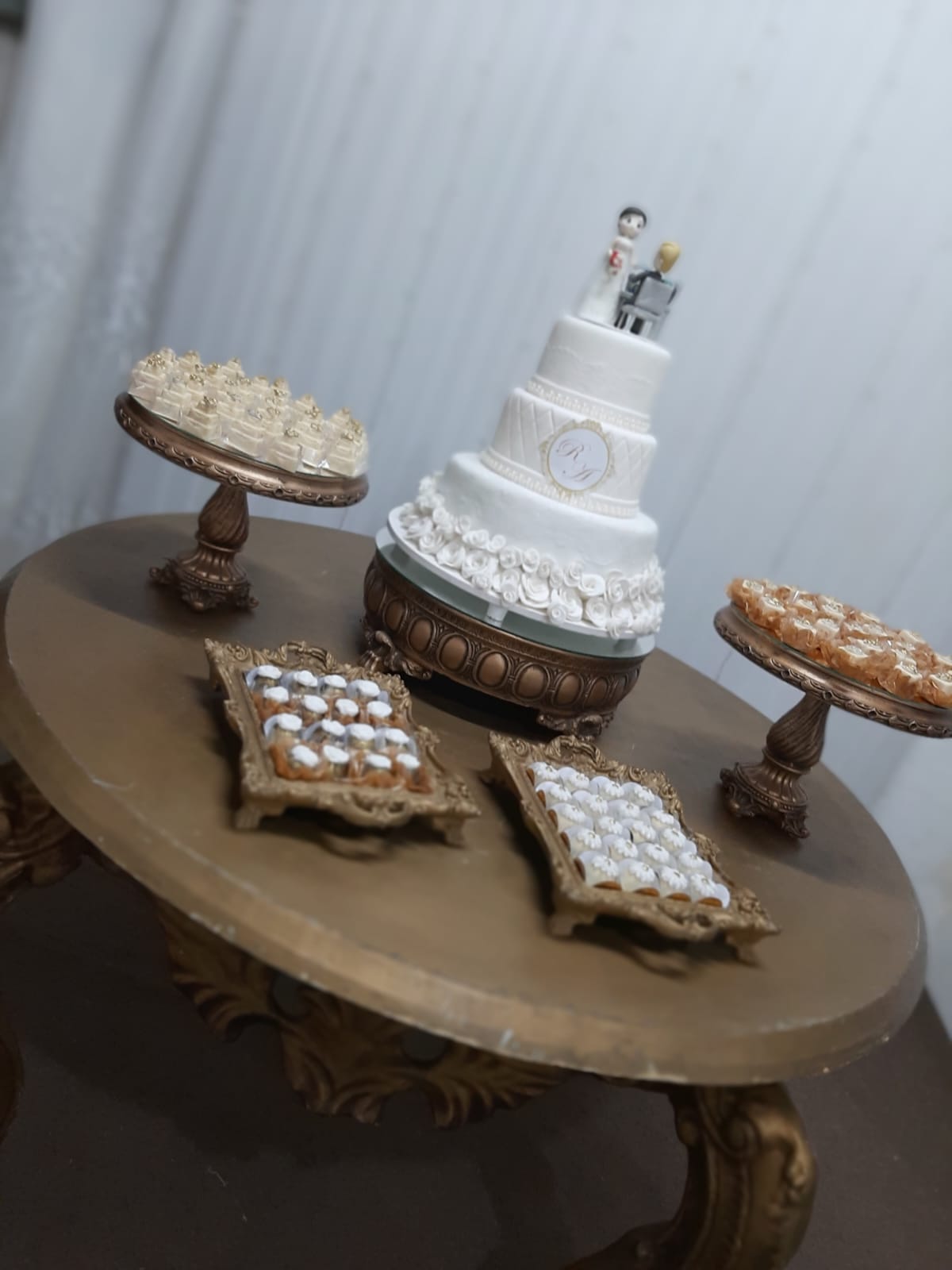 Mesa de bolo e doces finos montada para uma festa de casamento